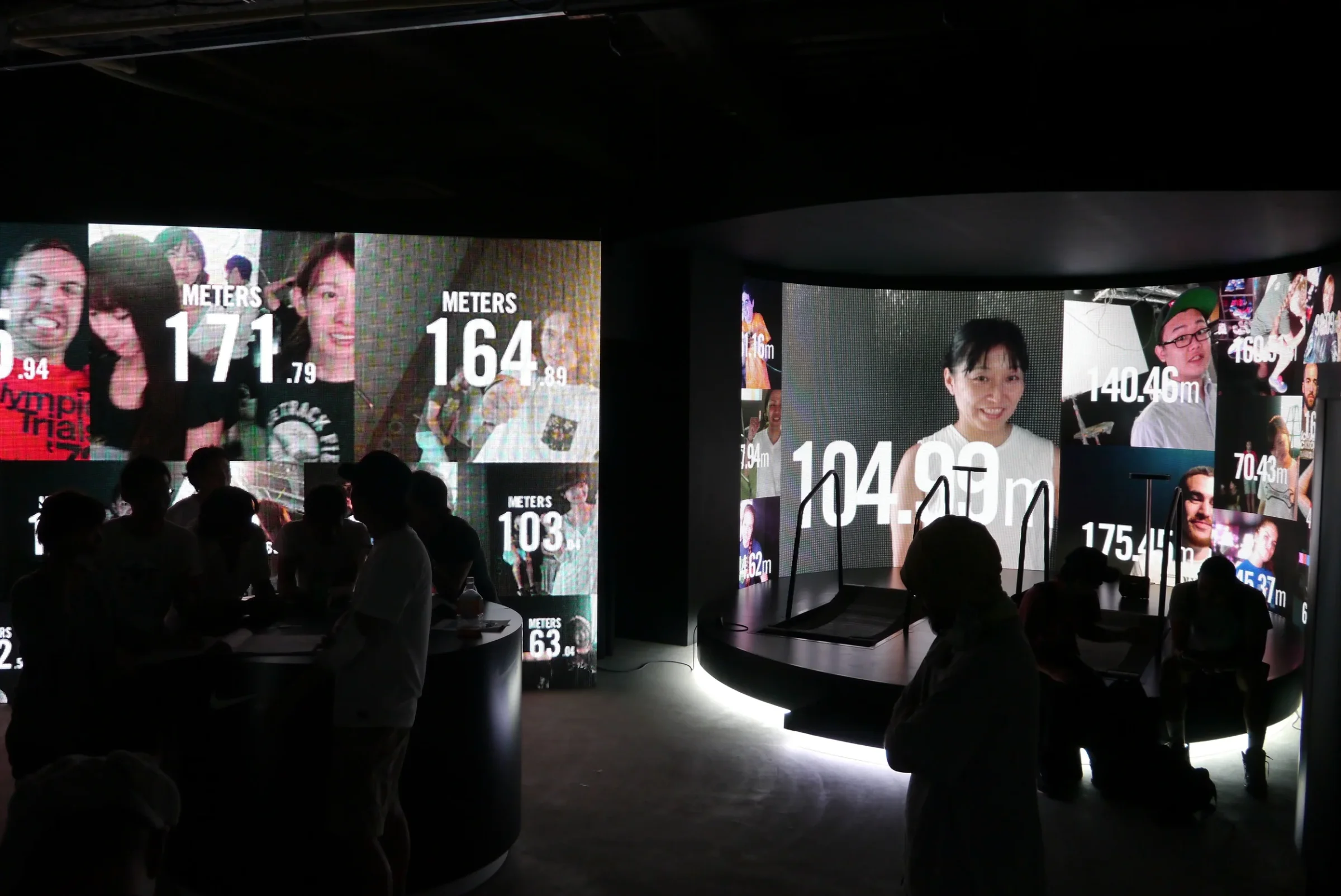 Wide shot of the Nike Ugokidase Station installation with two curved treadmills and large curved LED walls