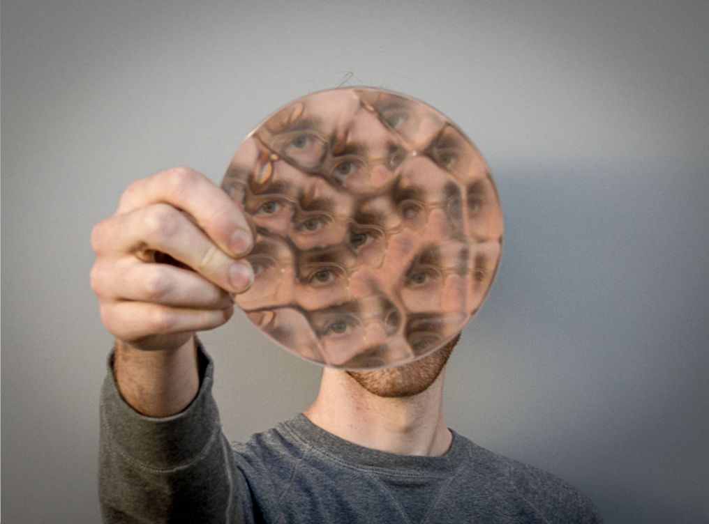 A 3D-printed transparent freeform lens that distorts the view of a face